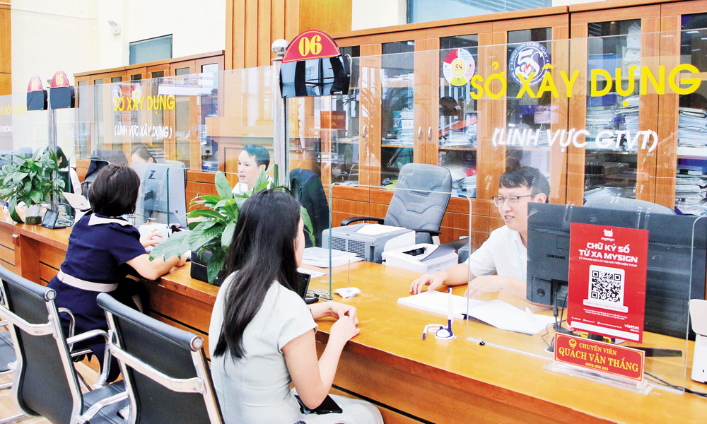 Cán bộ Sở Xây dựng hướng dẫn thực hiện các thủ tục hành chính tại Trung tâm Phục vụ hành chính công tỉnh. Ảnh: Hoài Thu.